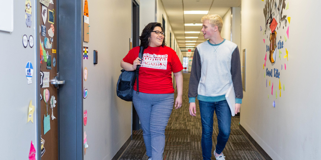 Two students walking down the hallway in North Hall.